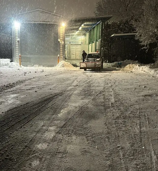 Winterdienst Ulm geräumte Zufahrt bei Schneefall mit Räumfahrzeug und Schneeaufwurf