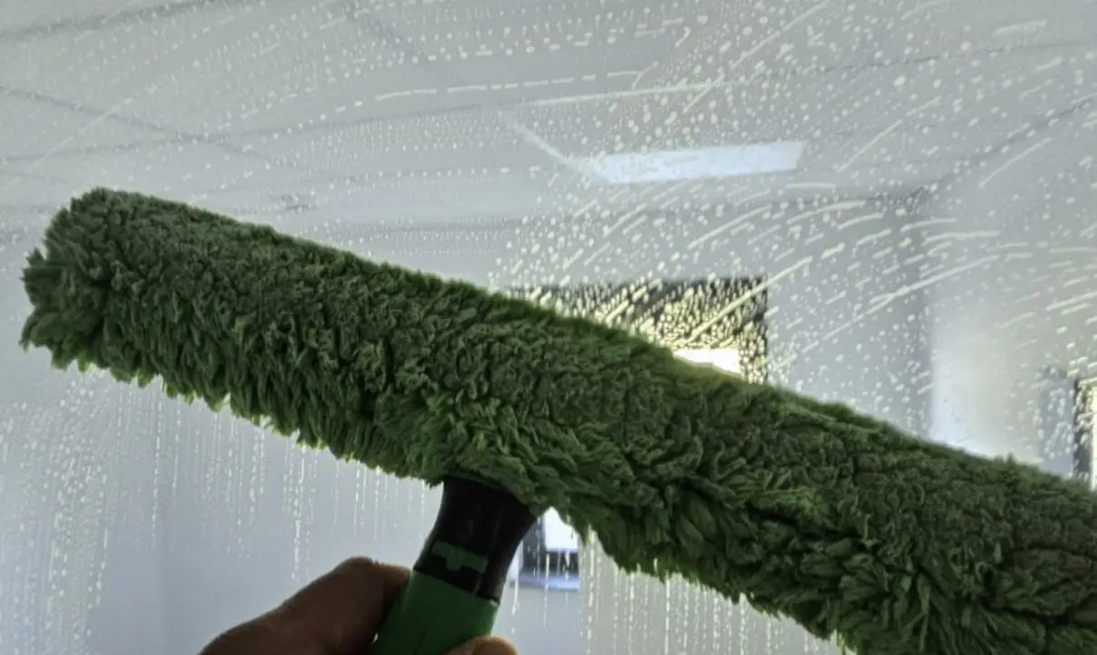 Mitarbeiter von Plura Gebäudereinigung Ulm bei der professionellen Glas und Rahmenreinigung einer Fensterfläche in Ulm