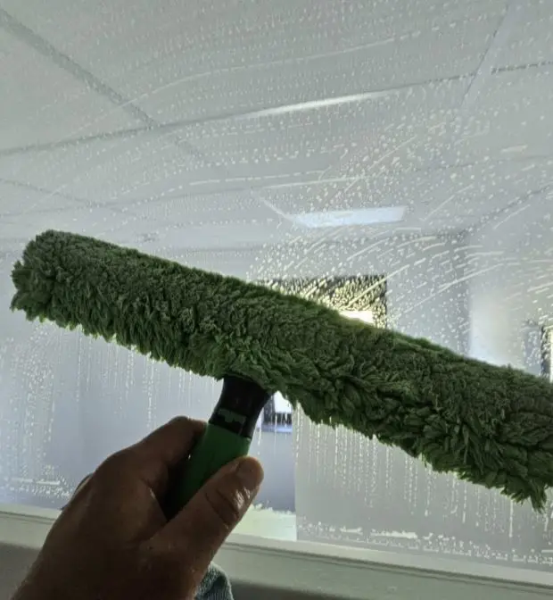 Mitarbeiter von Plura Gebäudereinigung Ulm bei der professionellen Glas und Rahmenreinigung einer Fensterfläche in Ulm